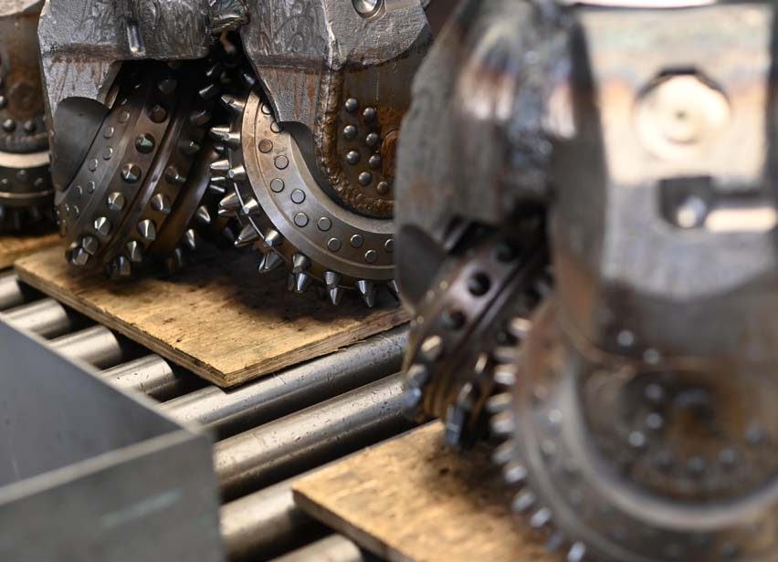 Roller cones with tungsten carbide inserts on tricone bit legs at the Volgaburmash plant
